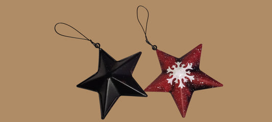 Black and red star-shaped ornaments with snowflake design on a white background
