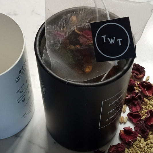 Tea packaging with dried herbs on a marble surface