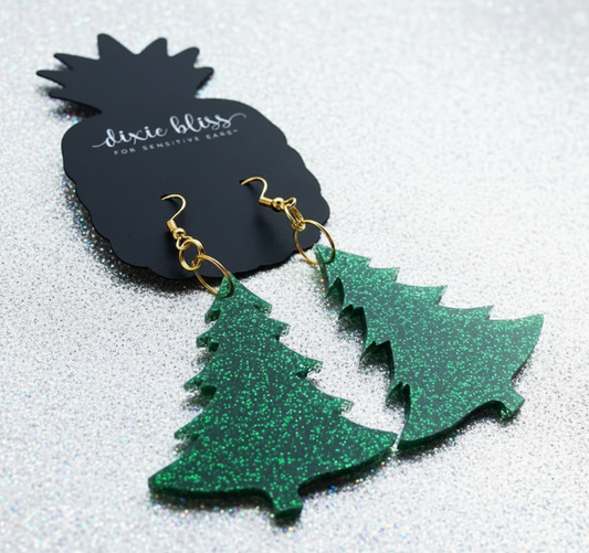Green glittery tree-shaped earrings on a Dixie Bliss branded card.