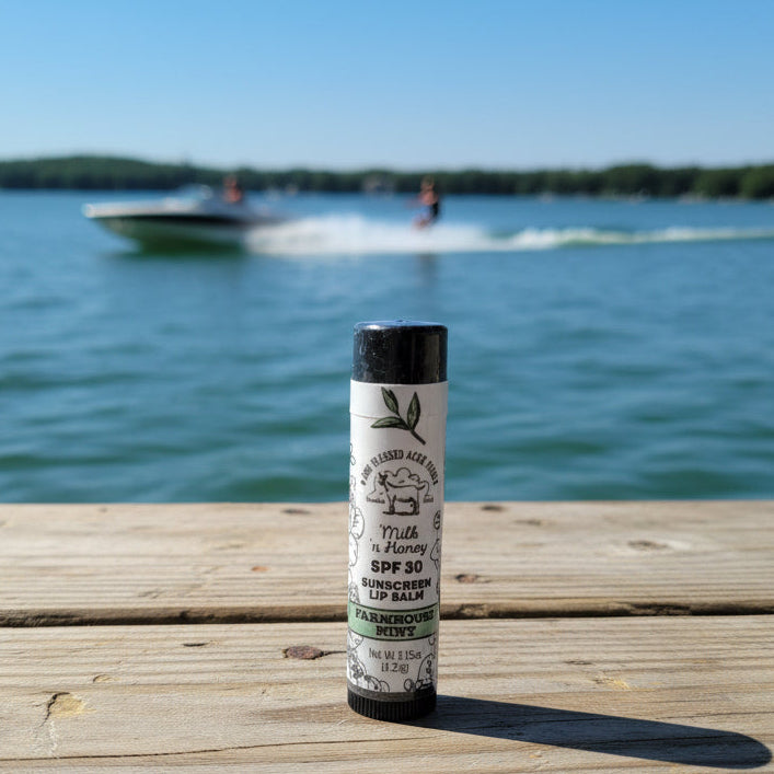 Lip balm on a wooden dock with a lake and boat in the background