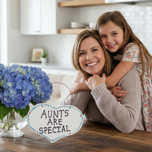 Woman and child in a kitchen with a sign saying 'Aunts are special'.