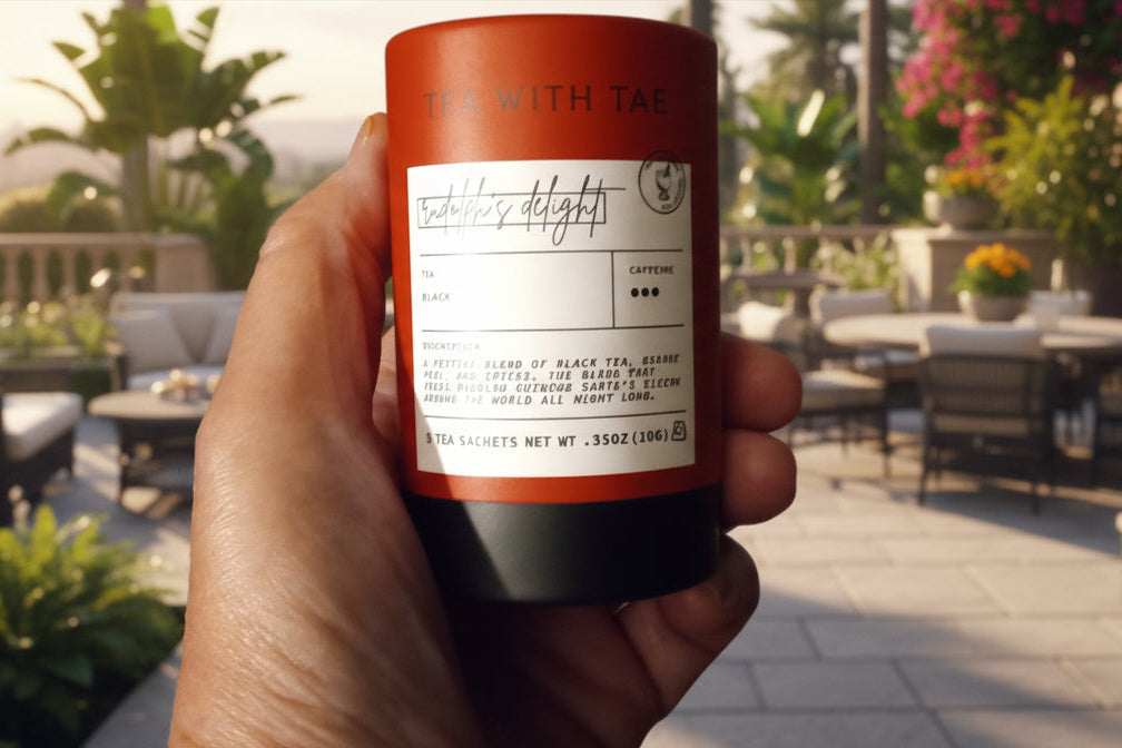 Hand holding a red cylindrical container with a label against a wooden background