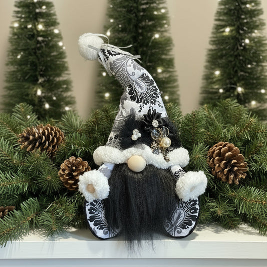 Decorative gnome with black and white hat and outfit, surrounded by pine cones and greenery.