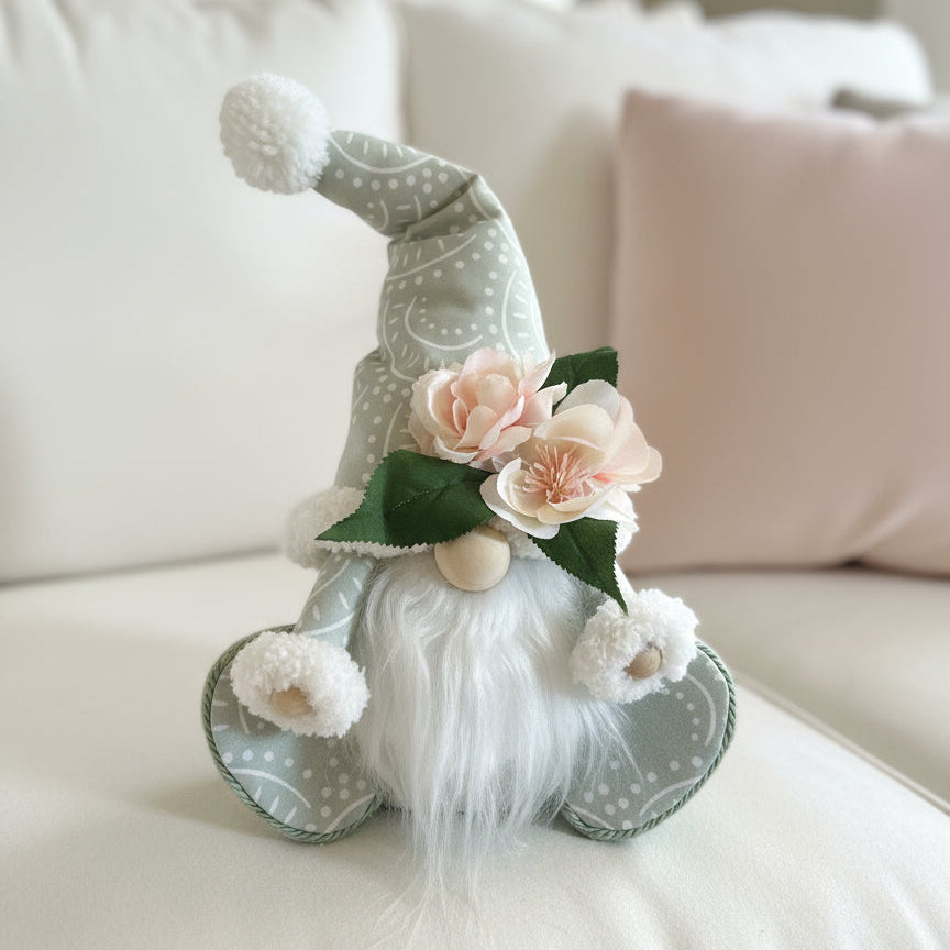 Decorative gnome with flowers on a light-colored surface