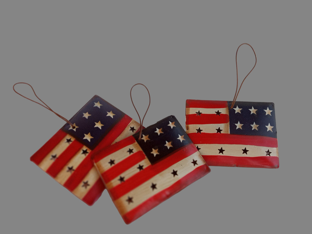 Four wooden American flag ornaments on a white background