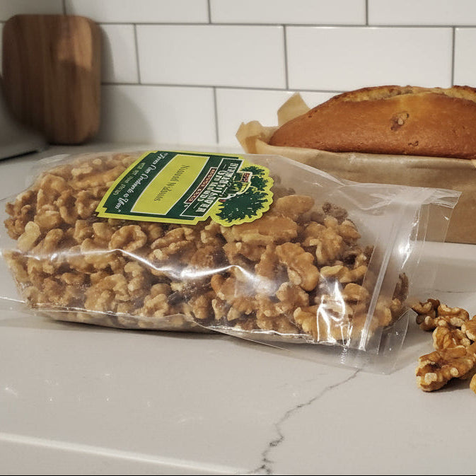 Bag of walnuts on a kitchen counter with scattered walnuts.