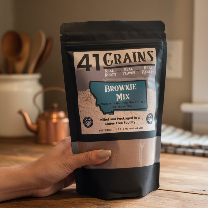 Hand holding a package of 41 Grains Brownie Mix on a colorful quilted surface.